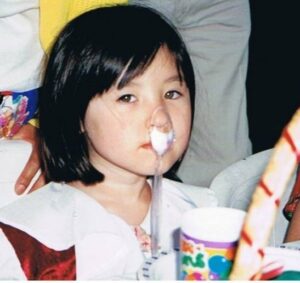 Andrina as a sullen kid with ice cream in a spoon hanging off her nose
